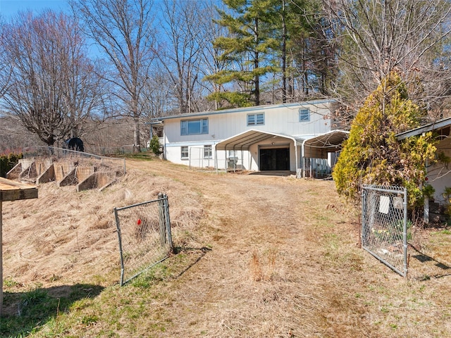 view of front of home with a carport, a gate, and fence