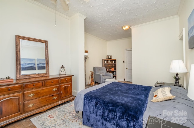 bedroom with ceiling fan, a textured ceiling, and ornamental molding