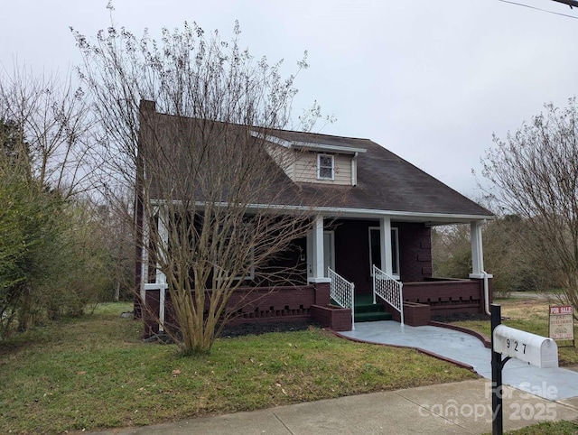 view of front of property featuring covered porch and a front lawn