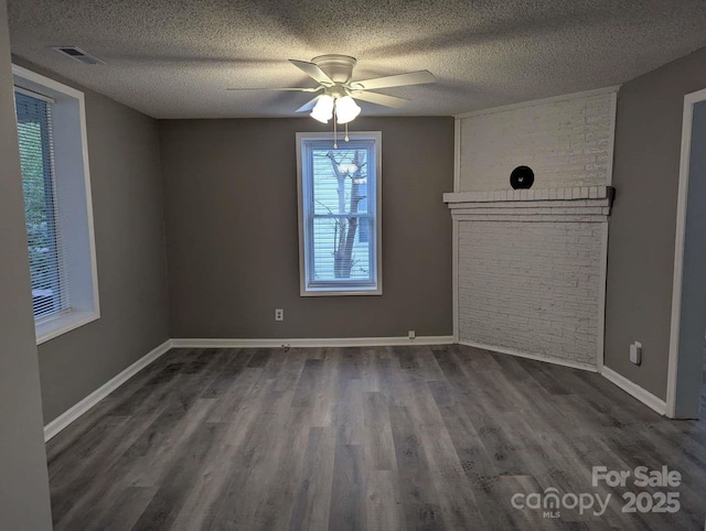 empty room with a ceiling fan, visible vents, wood finished floors, baseboards, and a textured ceiling