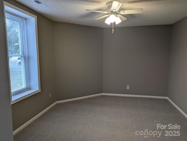 unfurnished room featuring visible vents, baseboards, ceiling fan, carpet flooring, and a textured ceiling