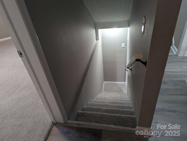 stairs with baseboards and carpet floors