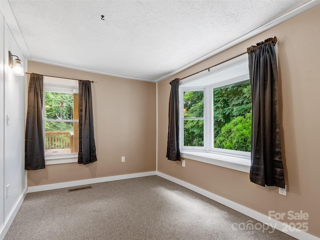 unfurnished room featuring visible vents, baseboards, and a textured ceiling