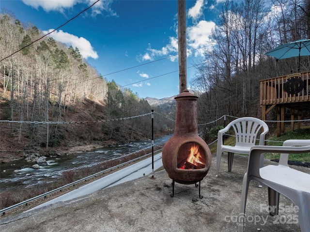 view of patio featuring a fire pit and a view of trees