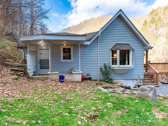 rear view of property featuring a shingled roof