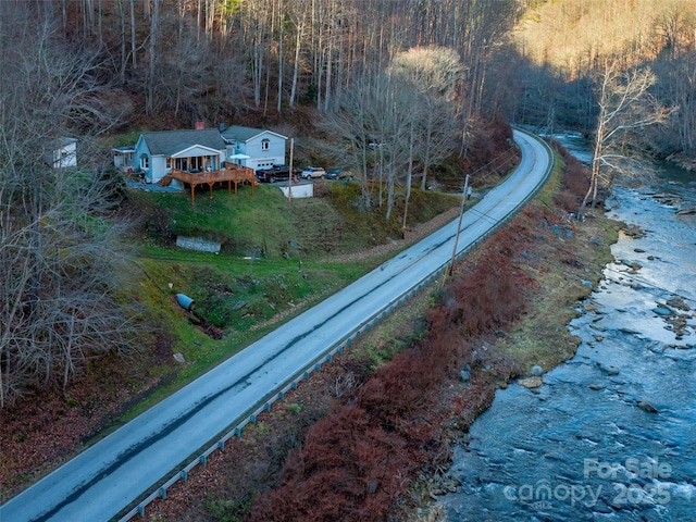 aerial view of property and surrounding area with a heavily wooded area