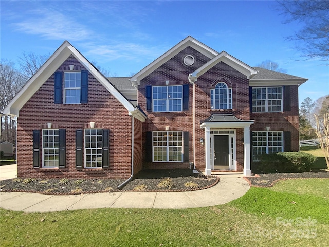 view of front of home with brick siding and a front lawn