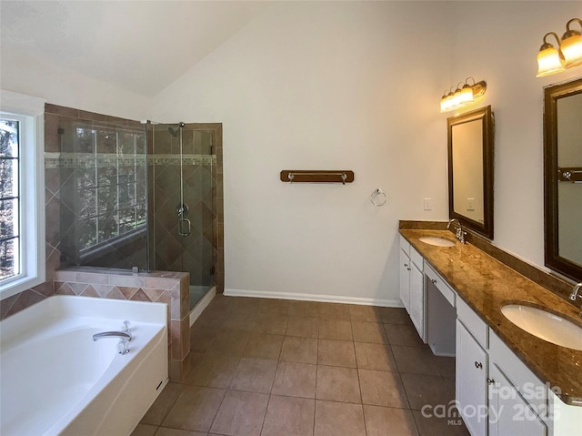 full bath with lofted ceiling, double vanity, a stall shower, and a sink