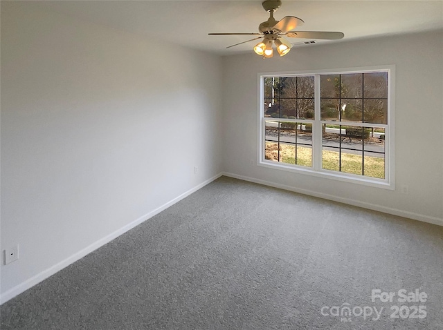 carpeted empty room featuring baseboards and a ceiling fan