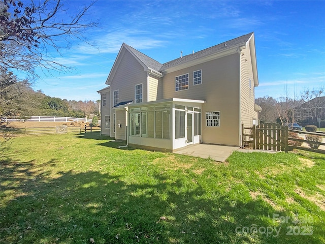 back of house featuring a lawn, fence, and a sunroom