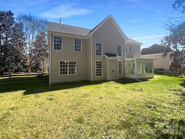 back of house with a lawn and a sunroom