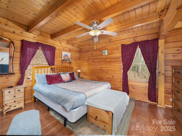 bedroom featuring beam ceiling, wood walls, wooden ceiling, and hardwood / wood-style flooring