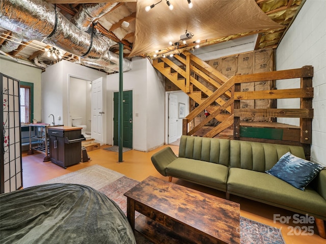 living room featuring stairway and finished concrete floors