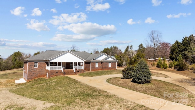 ranch-style house featuring concrete driveway, brick siding, covered porch, and a front lawn