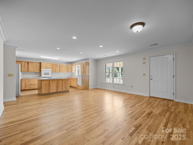 kitchen with light wood finished floors, a kitchen island, crown molding, open floor plan, and white appliances