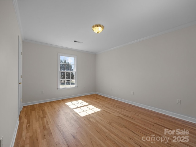 spare room featuring visible vents, baseboards, light wood-type flooring, and ornamental molding