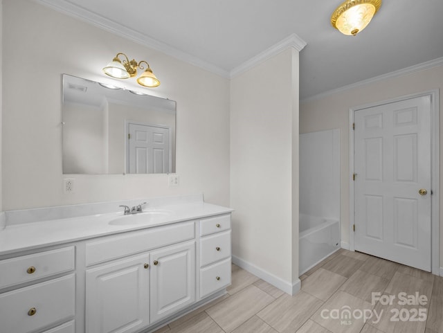 bathroom with baseboards, ornamental molding, vanity, and a bath