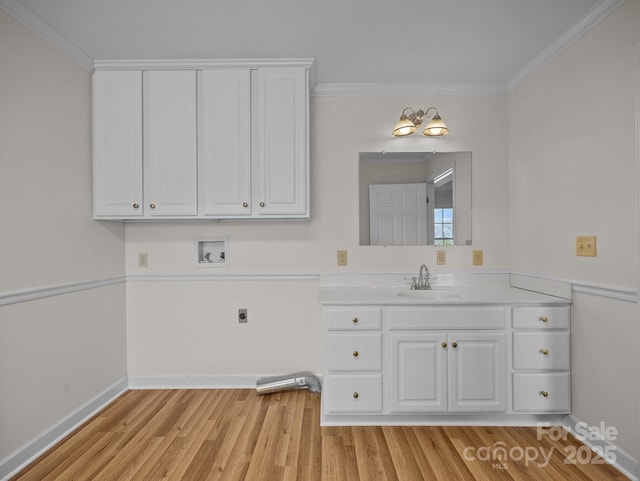 bathroom featuring baseboards, wood finished floors, ornamental molding, and vanity