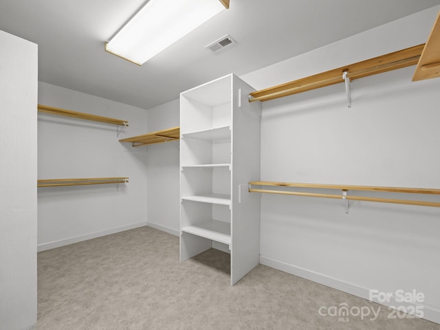 walk in closet with visible vents and carpet floors