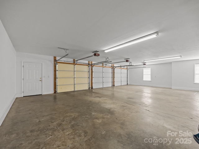 garage with a garage door opener and baseboards