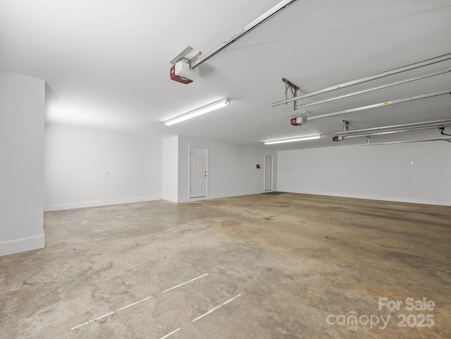 garage with a garage door opener and baseboards