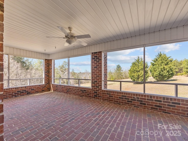 unfurnished sunroom featuring ceiling fan