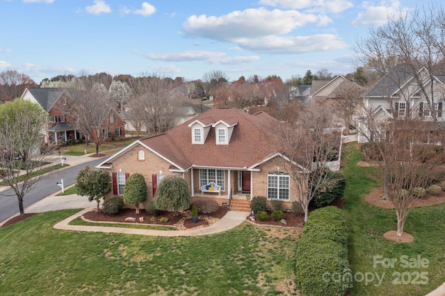 view of front facade featuring a front yard, brick siding, and a residential view