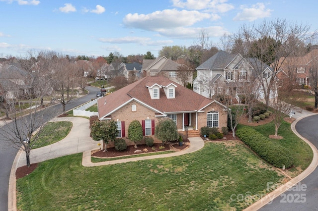 view of front of house featuring driveway, fence, a residential view, roof with shingles, and brick siding