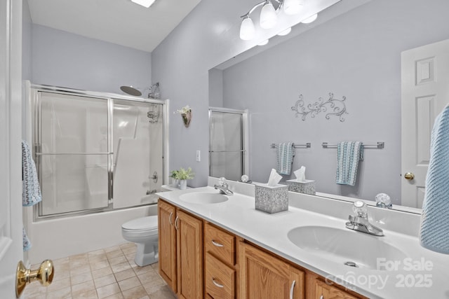 bathroom with tile patterned flooring, double vanity, toilet, and a sink