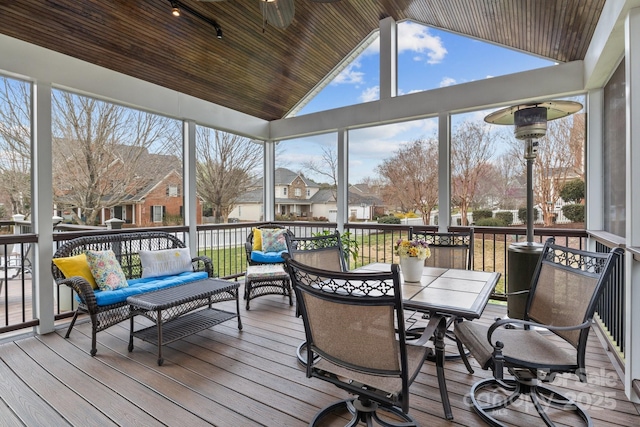 sunroom with a wealth of natural light, a residential view, and vaulted ceiling