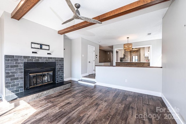 unfurnished living room featuring beamed ceiling, baseboards, a ceiling fan, and wood finished floors