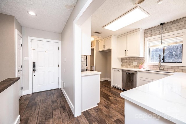 kitchen with a sink, dark wood-type flooring, stainless steel dishwasher, and white cabinetry