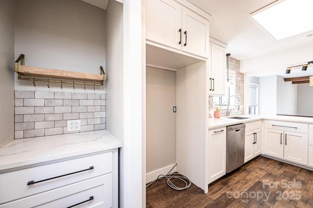 kitchen featuring tasteful backsplash, dark wood finished floors, dishwasher, white cabinetry, and a sink