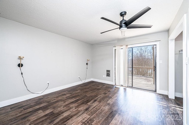 empty room with dark wood finished floors, baseboards, a textured ceiling, and a ceiling fan