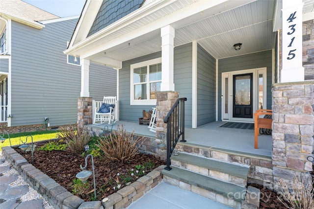 view of exterior entry featuring covered porch