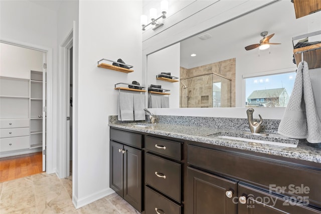 full bathroom with a sink, double vanity, ceiling fan, and a shower stall