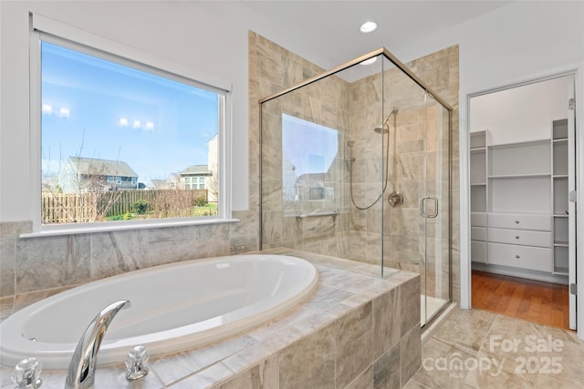 full bathroom with a garden tub, a spacious closet, recessed lighting, and a stall shower