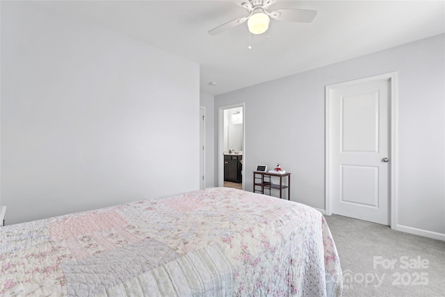 bedroom with ensuite bath, light colored carpet, a ceiling fan, and baseboards