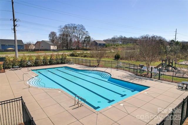 community pool with a patio and fence