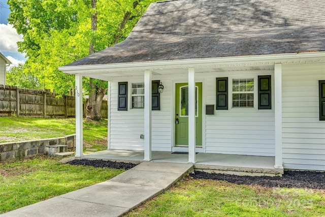 view of outdoor structure featuring a porch and fence