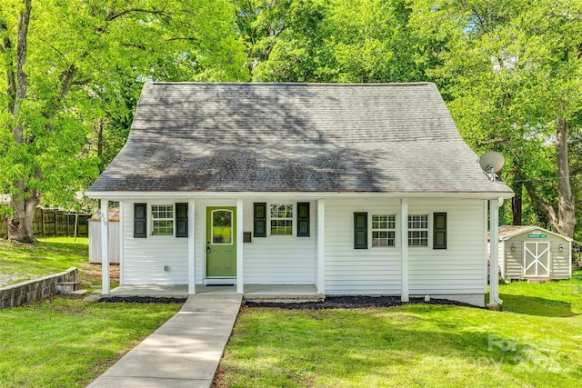 view of front of property featuring a storage unit, an outdoor structure, a front lawn, and fence