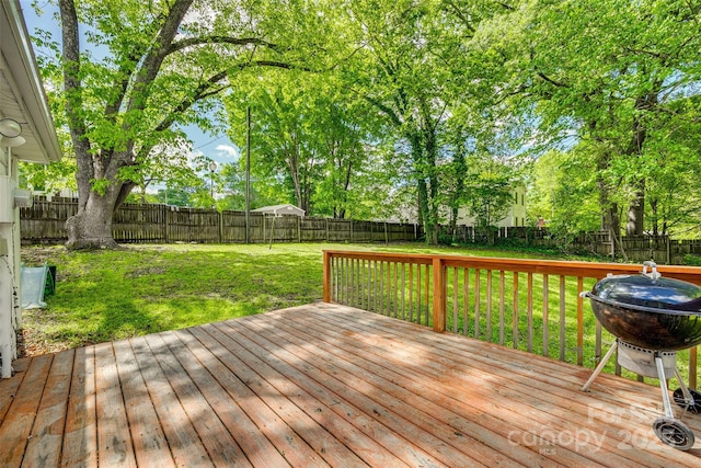 deck with a lawn, a fenced backyard, and grilling area