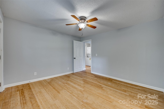 empty room with a textured ceiling, baseboards, ceiling fan, and wood finished floors