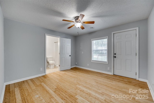 interior space featuring light wood-type flooring, baseboards, visible vents, and a ceiling fan