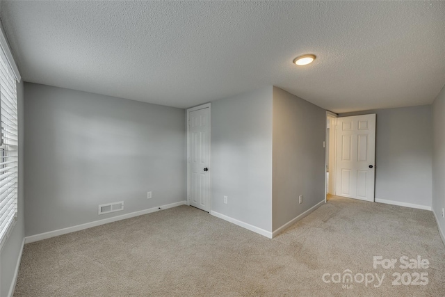 unfurnished room with visible vents, baseboards, and carpet