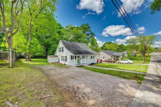 exterior space with fence, a storage shed, a yard, an outdoor structure, and driveway