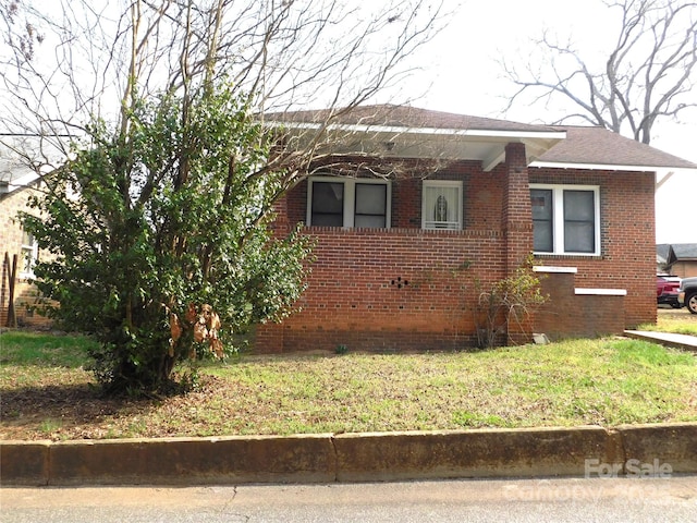 view of home's exterior with brick siding and a lawn