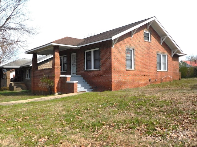 view of side of home with a yard and brick siding