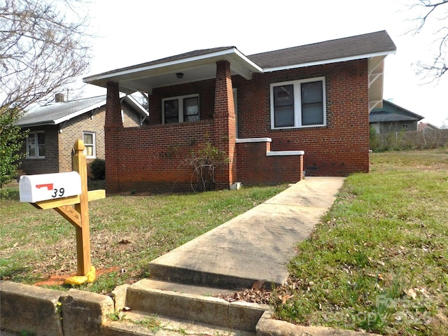 bungalow with brick siding and a front lawn