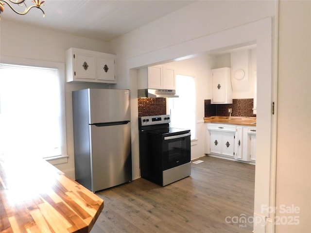 kitchen with under cabinet range hood, backsplash, wood finished floors, stainless steel appliances, and white cabinets